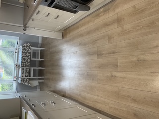 Oak-effect laminate flooring fitted through a bright kitchen and dining area