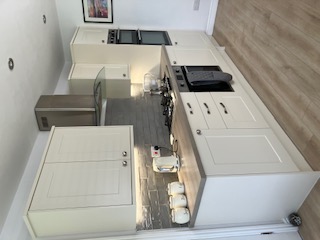 Cream shaker kitchen with wood-effect worktop, gas hob and extractor hood